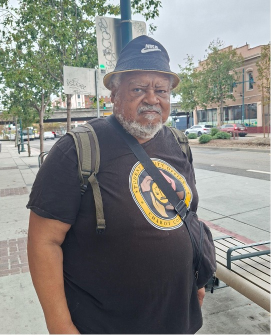 A portrait of a man wearing bucket hat and black t-shirt