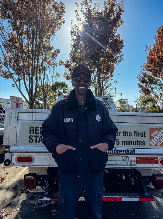 A portrait of a security guard standing in front of a Home Depot pickup truck