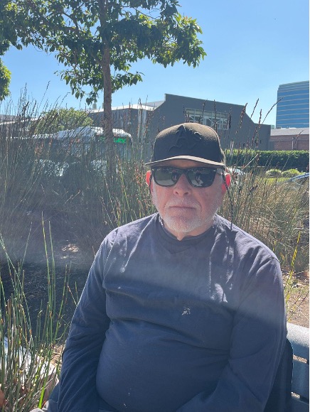 A close portrait of a old man with brown baseball cap and sunglasses.
