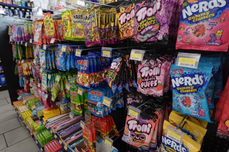 A retail store shelf filled with assorted candys