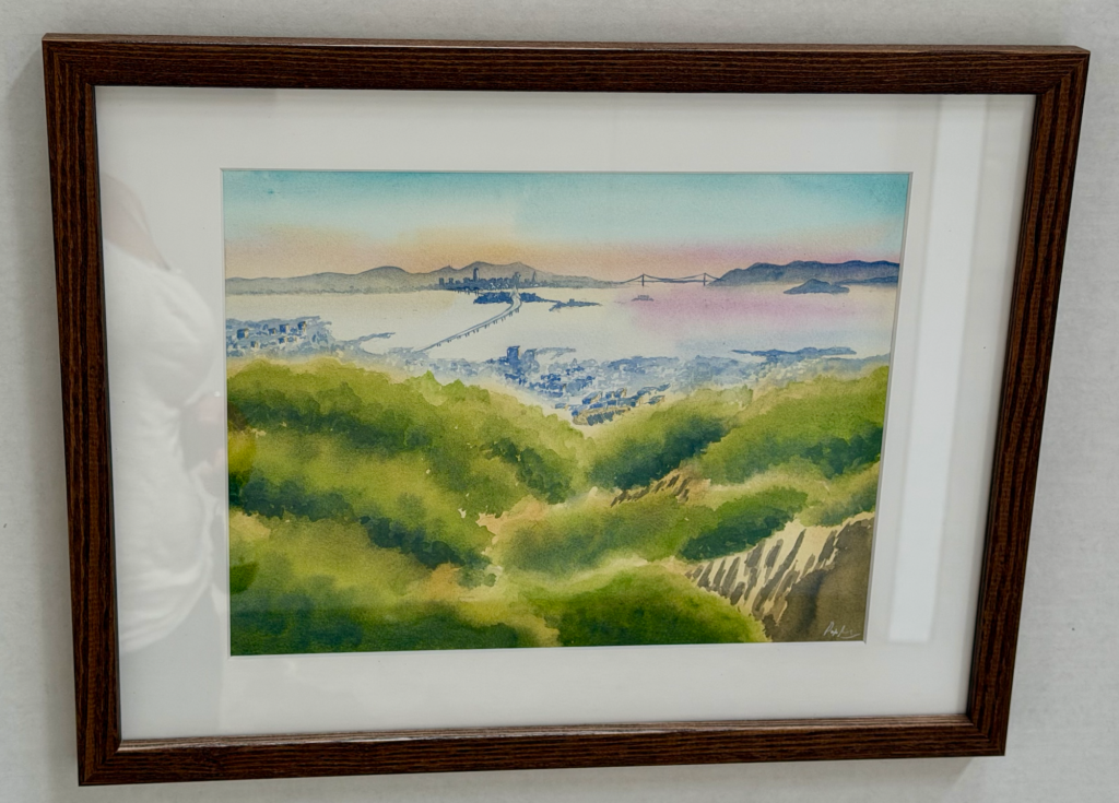 A painting of the bay and which starts beyong green hills and includes the Bay Bridge reaching Treasure Island and stretching across to San Francisco, whose hills and Golden Gate Bridge are in the far view.